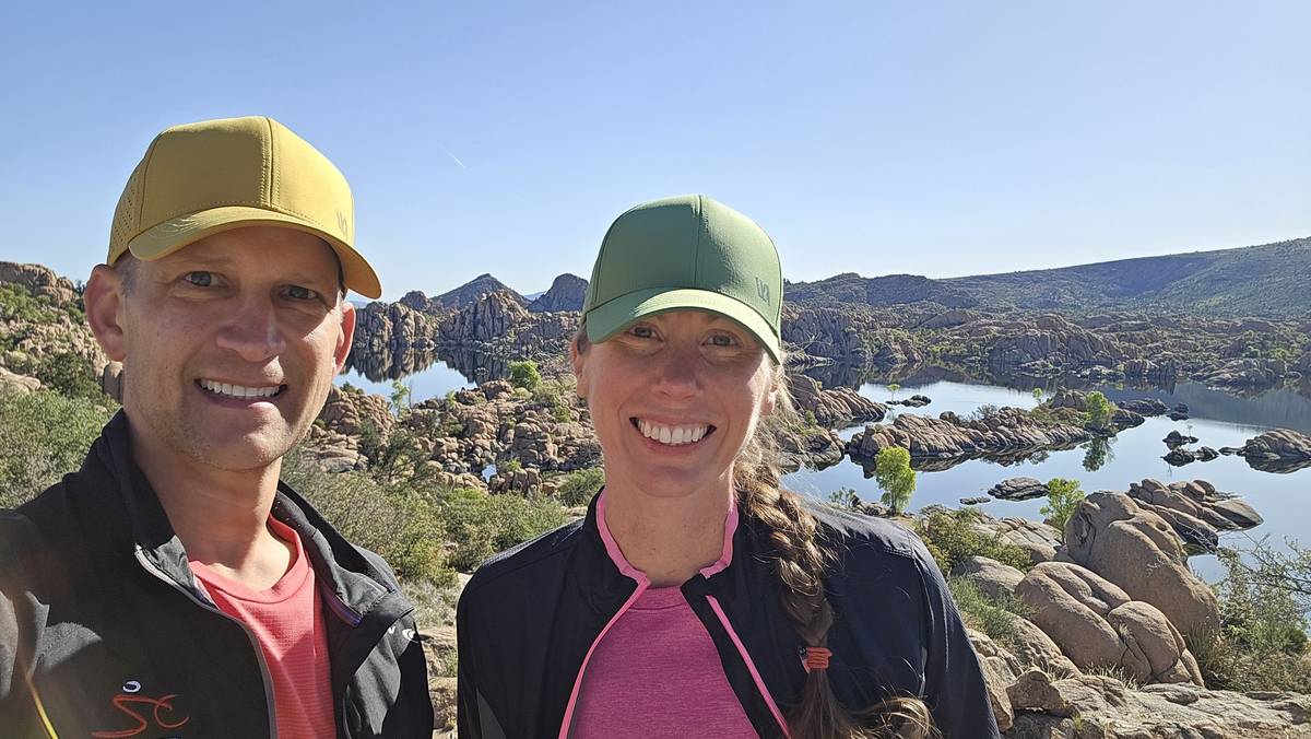 Andrew and Ashley Tepen, co-founders of RunWiki, smiling in running caps and jackets above the granite boulders of Watson Lake in Prescott, Arizona, before the Whiskey Basin Trail Race